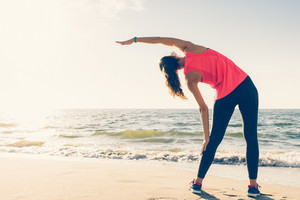 graphicstock athletic girl on the beach in the headphones makes stretching in the morning BZbv6TohPZ thumb